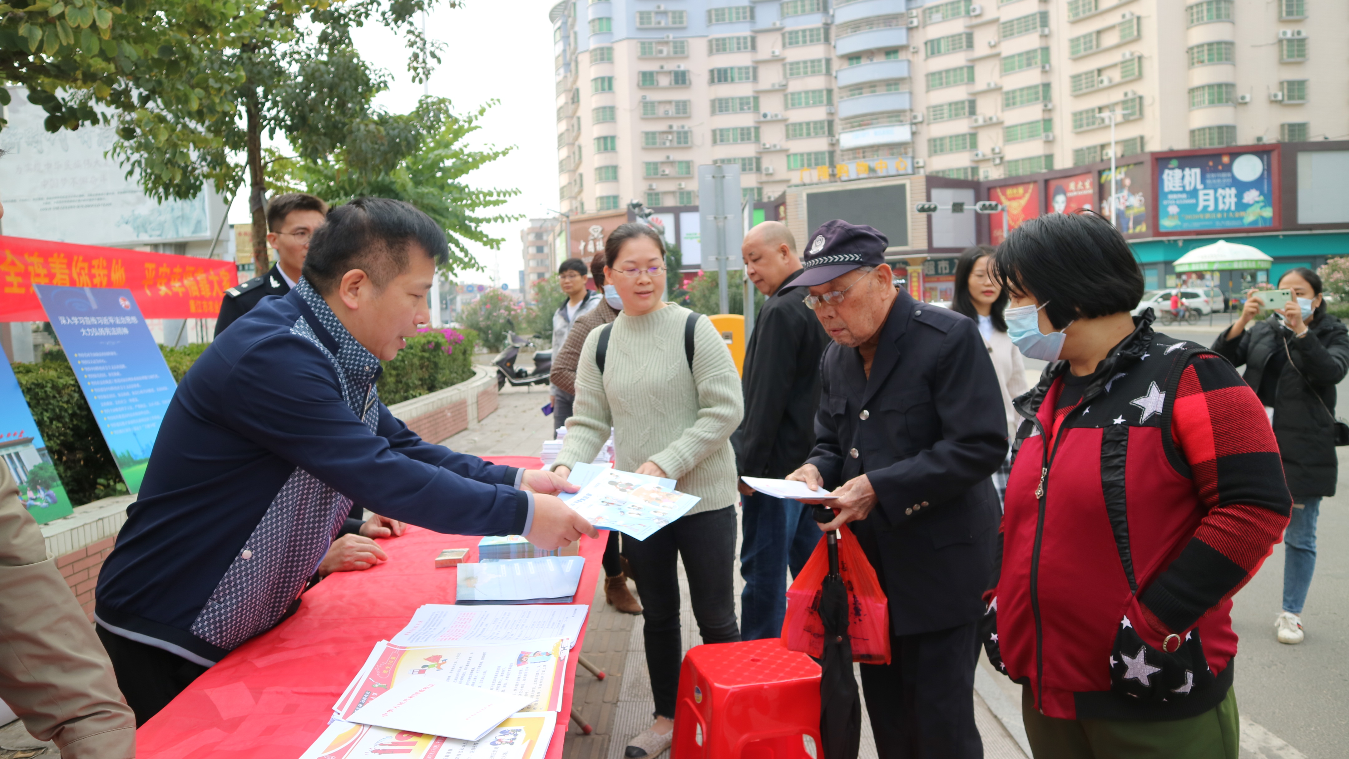 廉江市农业农村局副局长廖赟向群众派发消防安全以及宪法法律知识宣传资料